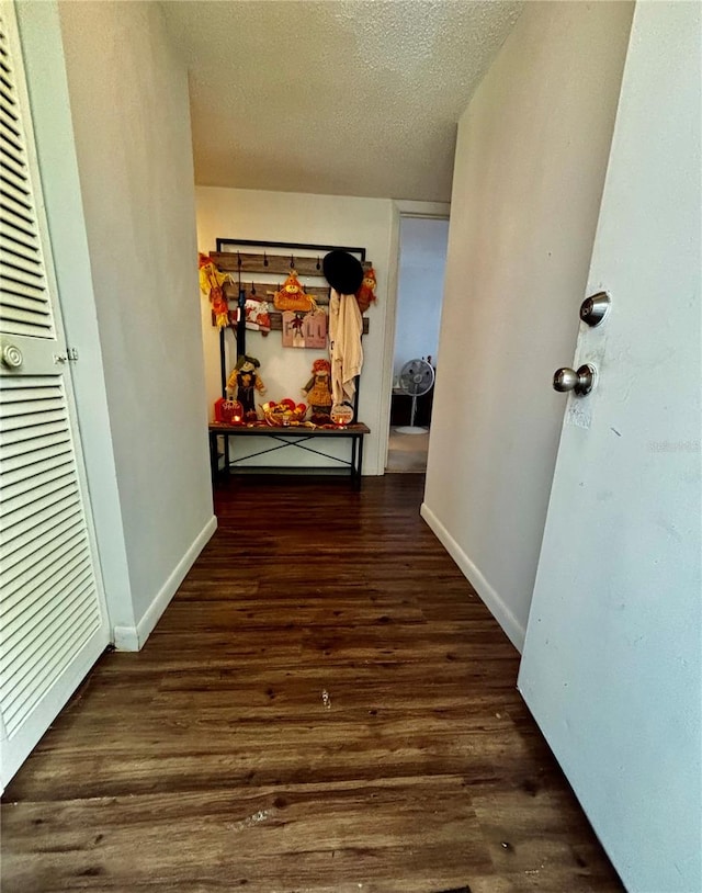 hall featuring a textured ceiling and dark hardwood / wood-style flooring