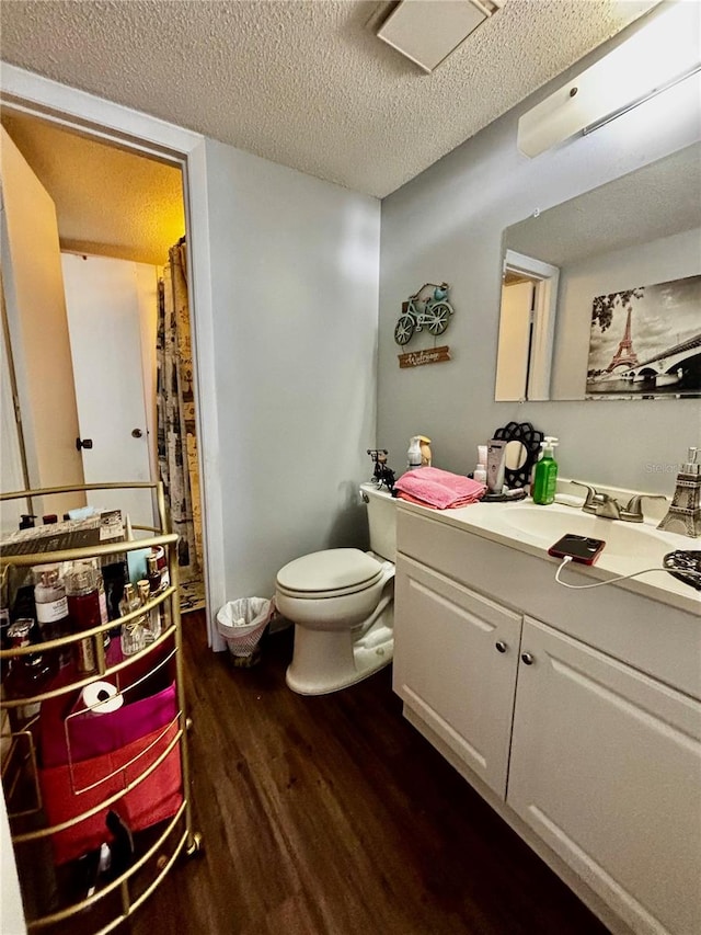 bathroom featuring vanity, a textured ceiling, toilet, and hardwood / wood-style flooring