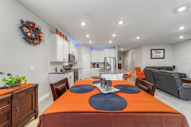 tiled dining room featuring sink