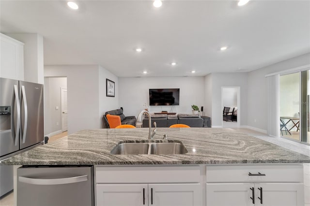 kitchen featuring white cabinets, appliances with stainless steel finishes, and light stone countertops