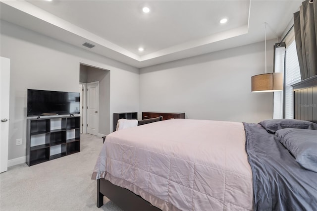 carpeted bedroom with a tray ceiling