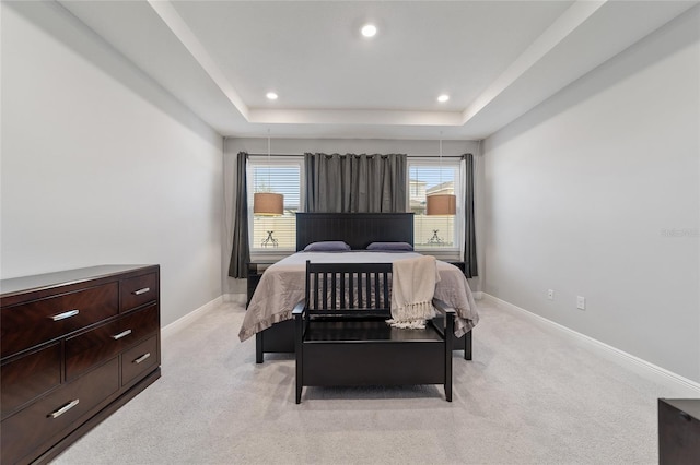 carpeted bedroom with a tray ceiling