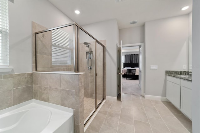 bathroom featuring independent shower and bath, vanity, and tile patterned floors