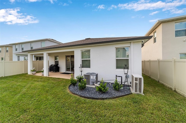 back of property with a yard, a patio, and central air condition unit