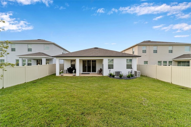 rear view of property with cooling unit, a lawn, and a patio