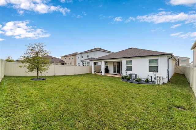 back of house with a lawn, a patio, and central AC