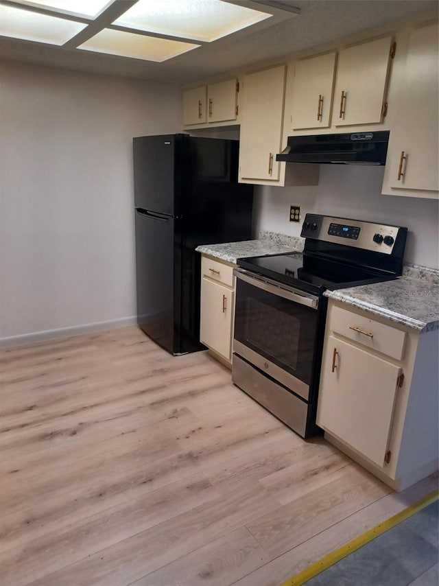 kitchen with light hardwood / wood-style flooring, stainless steel appliances, and cream cabinets