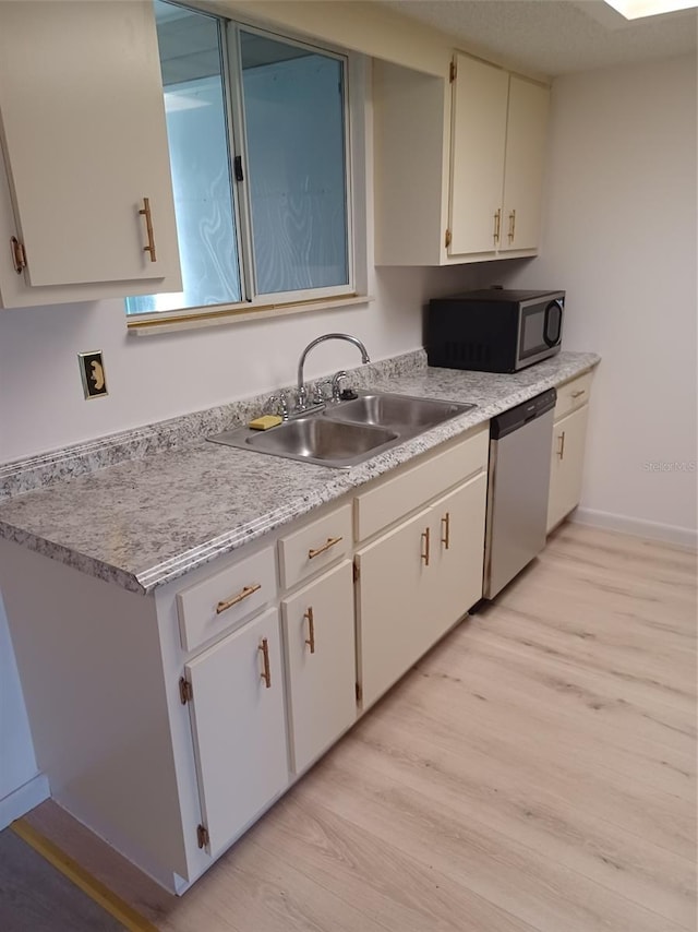 kitchen featuring light hardwood / wood-style flooring, white cabinetry, appliances with stainless steel finishes, and sink