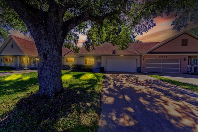 ranch-style house featuring a yard and a garage