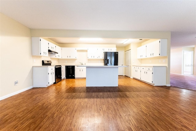 kitchen with black appliances, white cabinetry, hardwood / wood-style floors, and sink