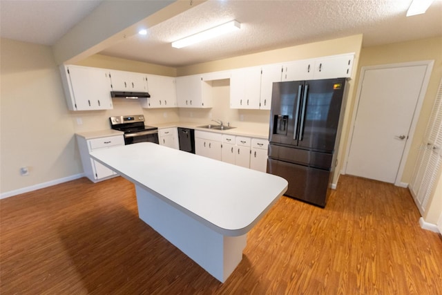 kitchen with stainless steel range with electric cooktop, black fridge, a textured ceiling, and white cabinetry