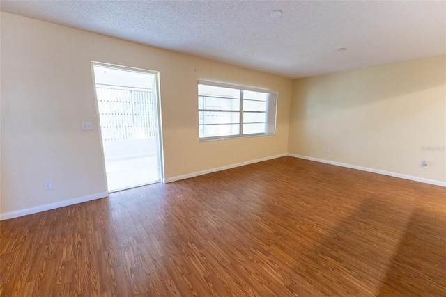 spare room featuring hardwood / wood-style floors and a textured ceiling