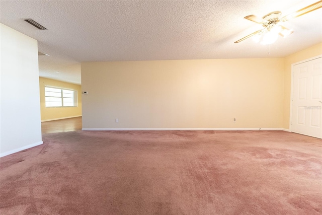 carpeted spare room featuring ceiling fan and a textured ceiling