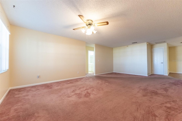 carpeted empty room with ceiling fan and a textured ceiling