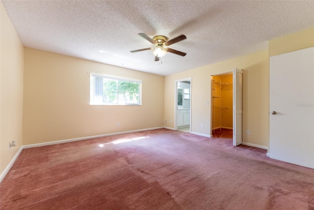 carpeted spare room featuring ceiling fan and a textured ceiling