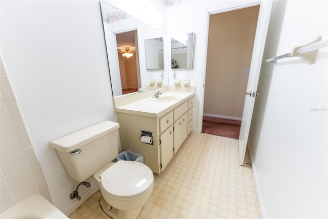 bathroom with a bathtub, vanity, and toilet