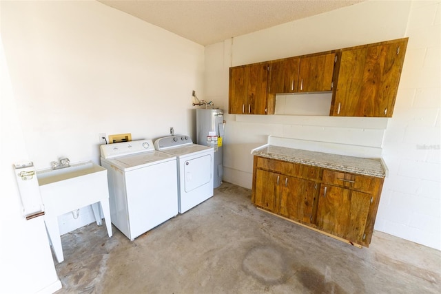 laundry area featuring washing machine and dryer, a textured ceiling, electric water heater, and cabinets