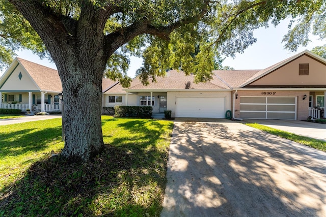 ranch-style house with a garage, a front lawn, and covered porch