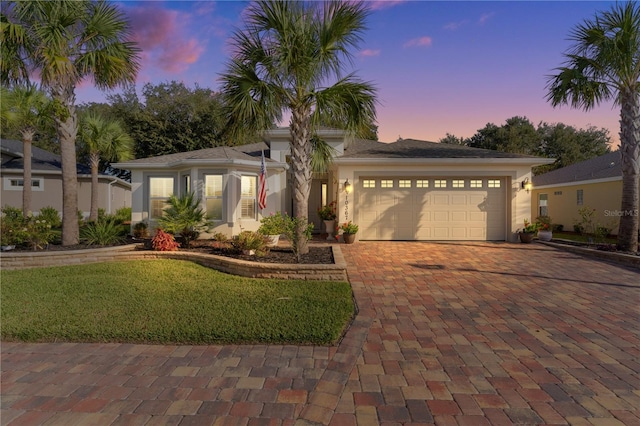 view of front of house featuring a garage and a lawn