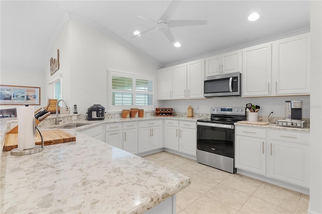 kitchen with lofted ceiling, sink, white cabinets, light tile patterned floors, and appliances with stainless steel finishes