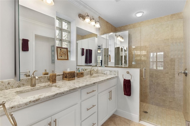 bathroom with a shower with door, a textured ceiling, vanity, and tile patterned flooring