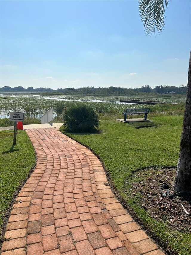 surrounding community with a yard and a water view