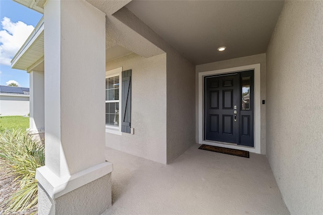 property entrance with stucco siding