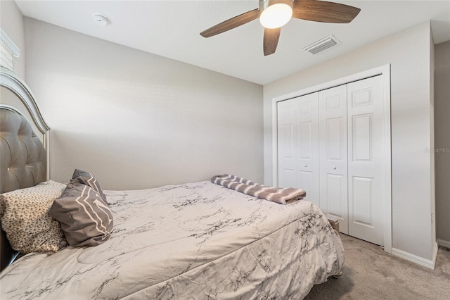 bedroom featuring ceiling fan, light colored carpet, and a closet