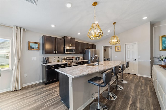 kitchen with lofted ceiling, sink, wood-type flooring, a kitchen island with sink, and stainless steel appliances