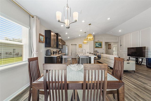 dining area with a wealth of natural light, vaulted ceiling, hardwood / wood-style flooring, and sink