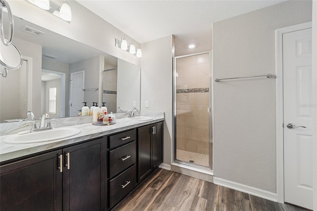 bathroom with hardwood / wood-style floors, walk in shower, and vanity