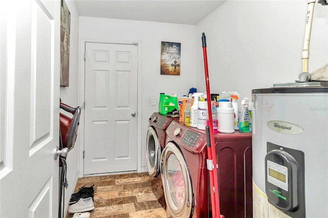 washroom featuring water heater, washing machine and clothes dryer, and hardwood / wood-style floors