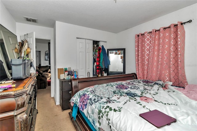 bedroom featuring light colored carpet, a closet, and a textured ceiling