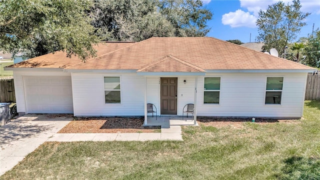 ranch-style home featuring a garage and a front lawn