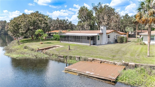 view of dock with a yard and a water view