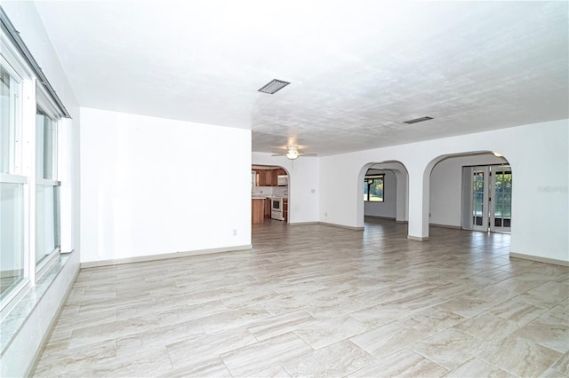 unfurnished living room featuring ceiling fan