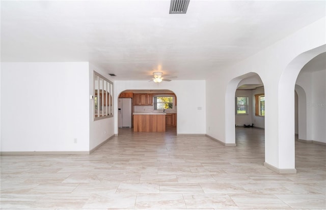 unfurnished living room featuring ceiling fan