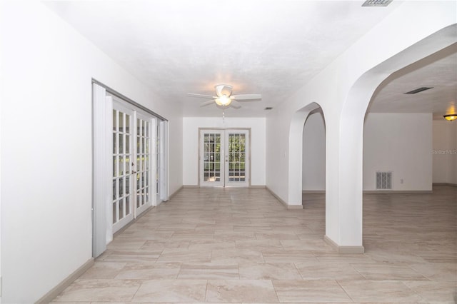 spare room with ceiling fan and french doors