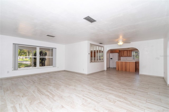 unfurnished living room with ceiling fan