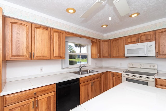 kitchen with ceiling fan, white appliances, sink, and a textured ceiling