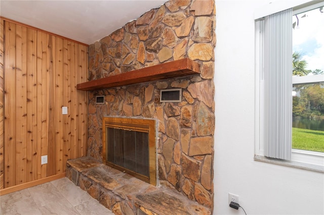 room details featuring a fireplace and wood walls