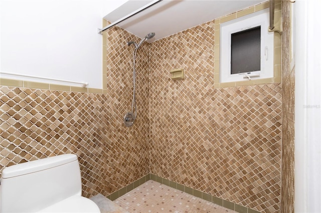 bathroom featuring a tile shower, tile walls, and toilet