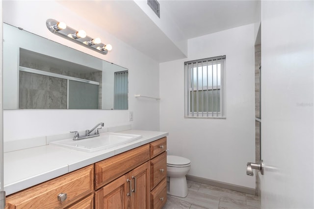 bathroom with vanity, a shower with shower door, and toilet