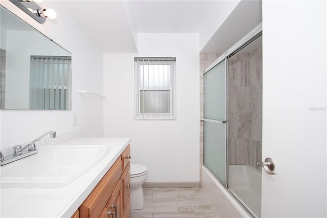 full bathroom with shower / bath combination with glass door, vanity, and toilet