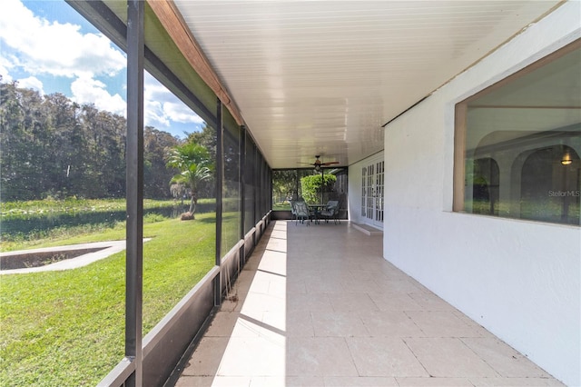 unfurnished sunroom with ceiling fan