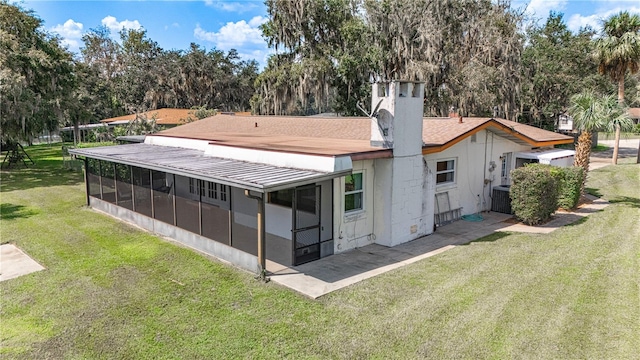 back of property with a sunroom and a yard