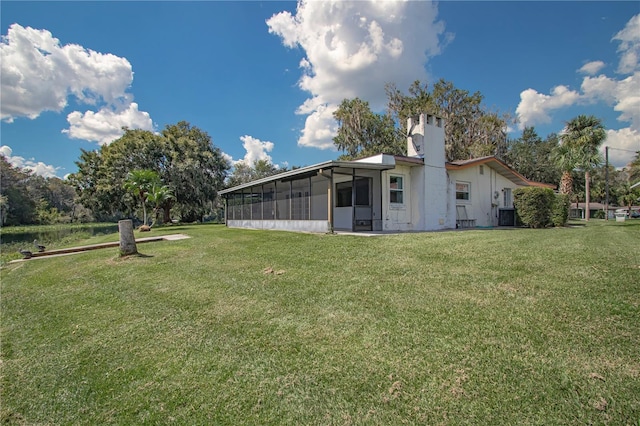 back of house with a yard, a sunroom, and central AC unit