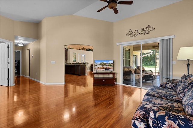 living room with ceiling fan, hardwood / wood-style flooring, and high vaulted ceiling