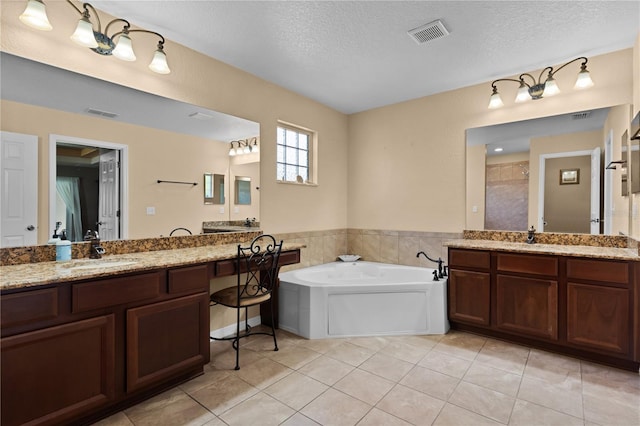 bathroom featuring a textured ceiling, shower with separate bathtub, vanity, and tile patterned floors