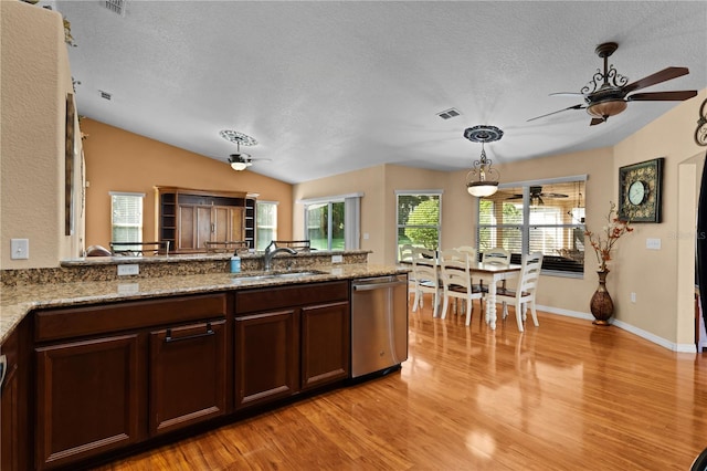 kitchen with light wood-type flooring, vaulted ceiling, stainless steel dishwasher, and sink